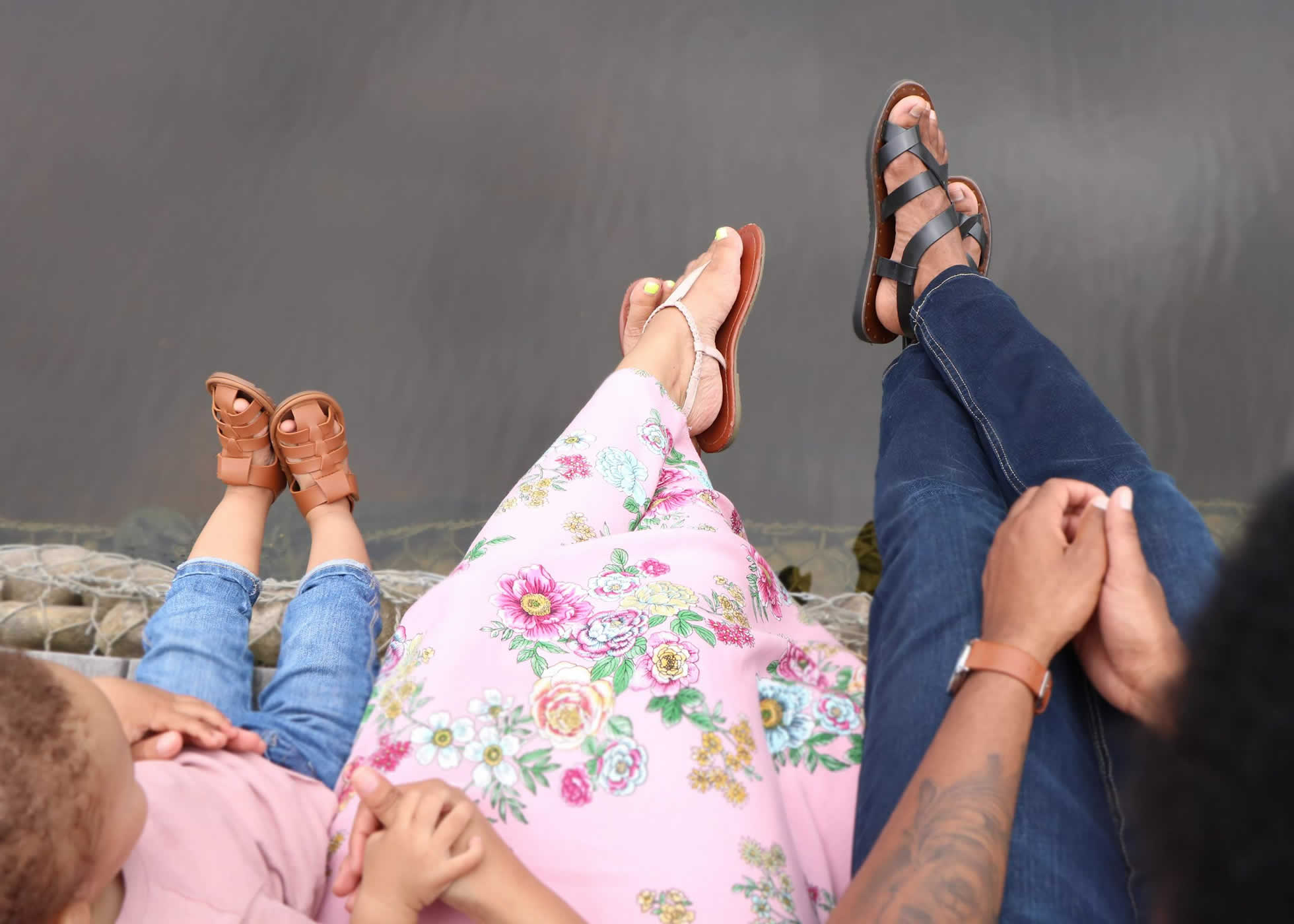 Family Photography: family seated in a row with feet over water, image taken from above